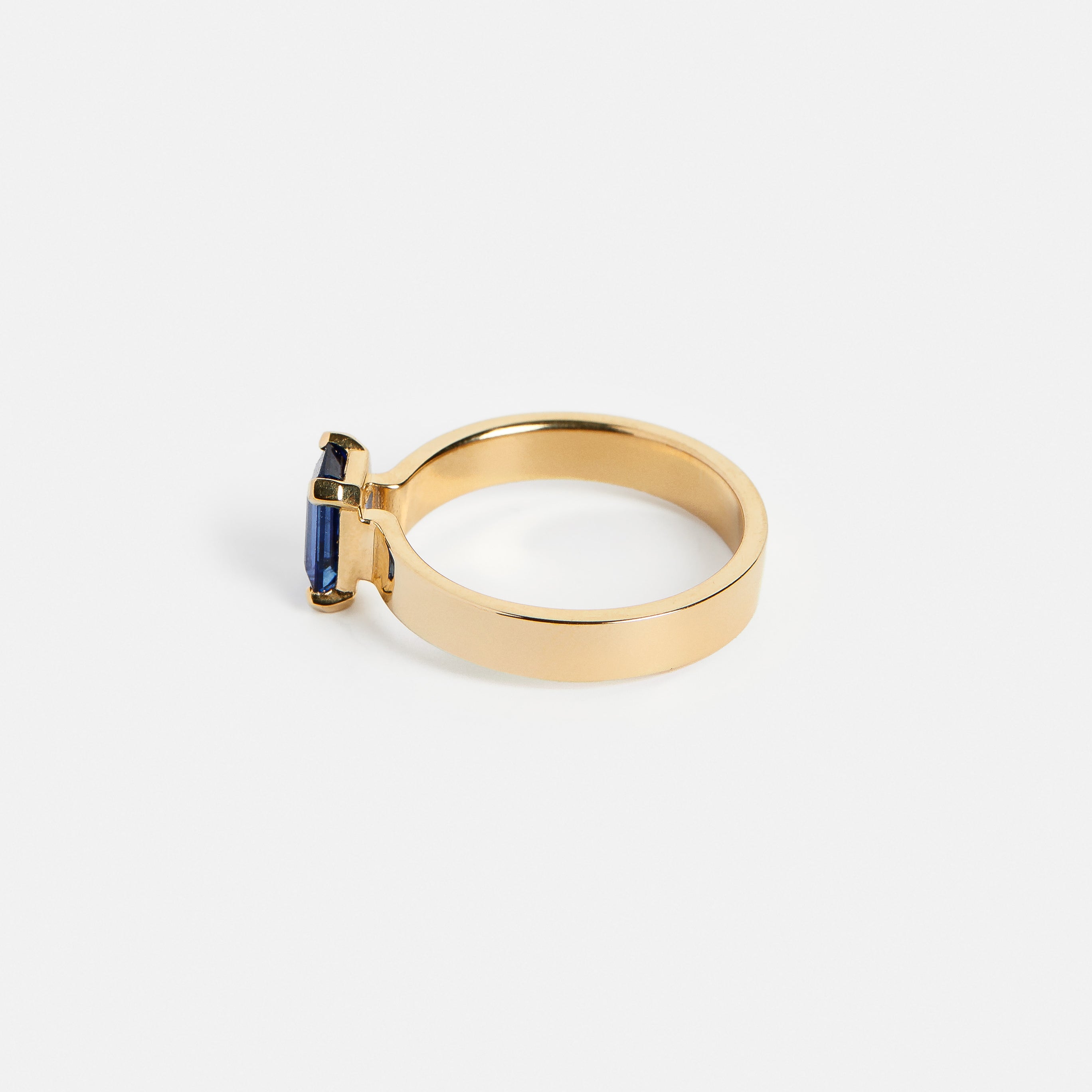 Unique thick band prong setting with emerald cut dark blue 1.25 carat sapphire in 14k yellow golds by SHW cool fine jewelry store in NYC