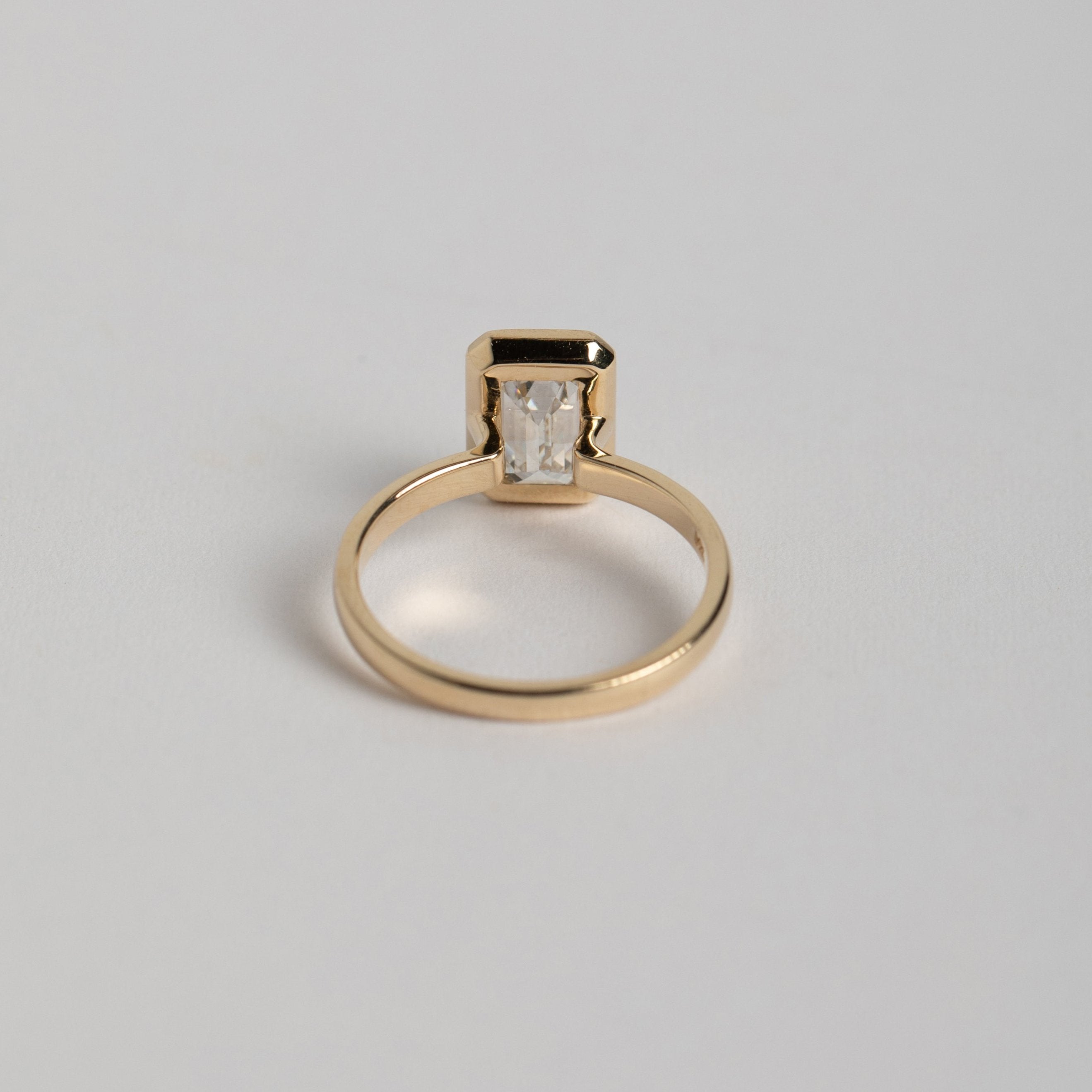 Simple Domed Band Bezel engagement ring with 1.5 carat laboratory emerald cut diamond in 14k yellow gold by SHW fine jewelry NYC near me