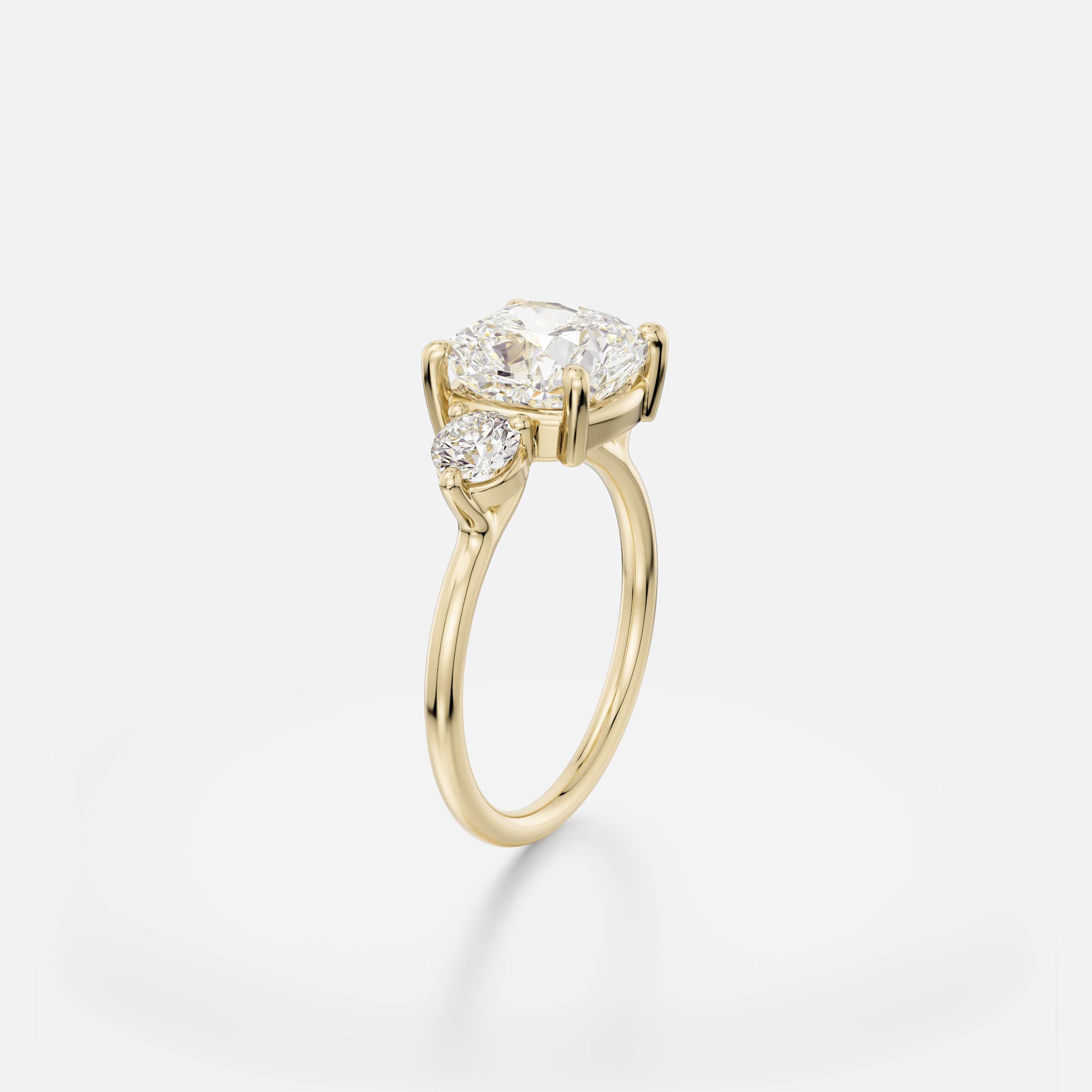 14k yellow gold engagement ring with 3.25 carat cushion diamond and round side stones in corner prong setting angle view