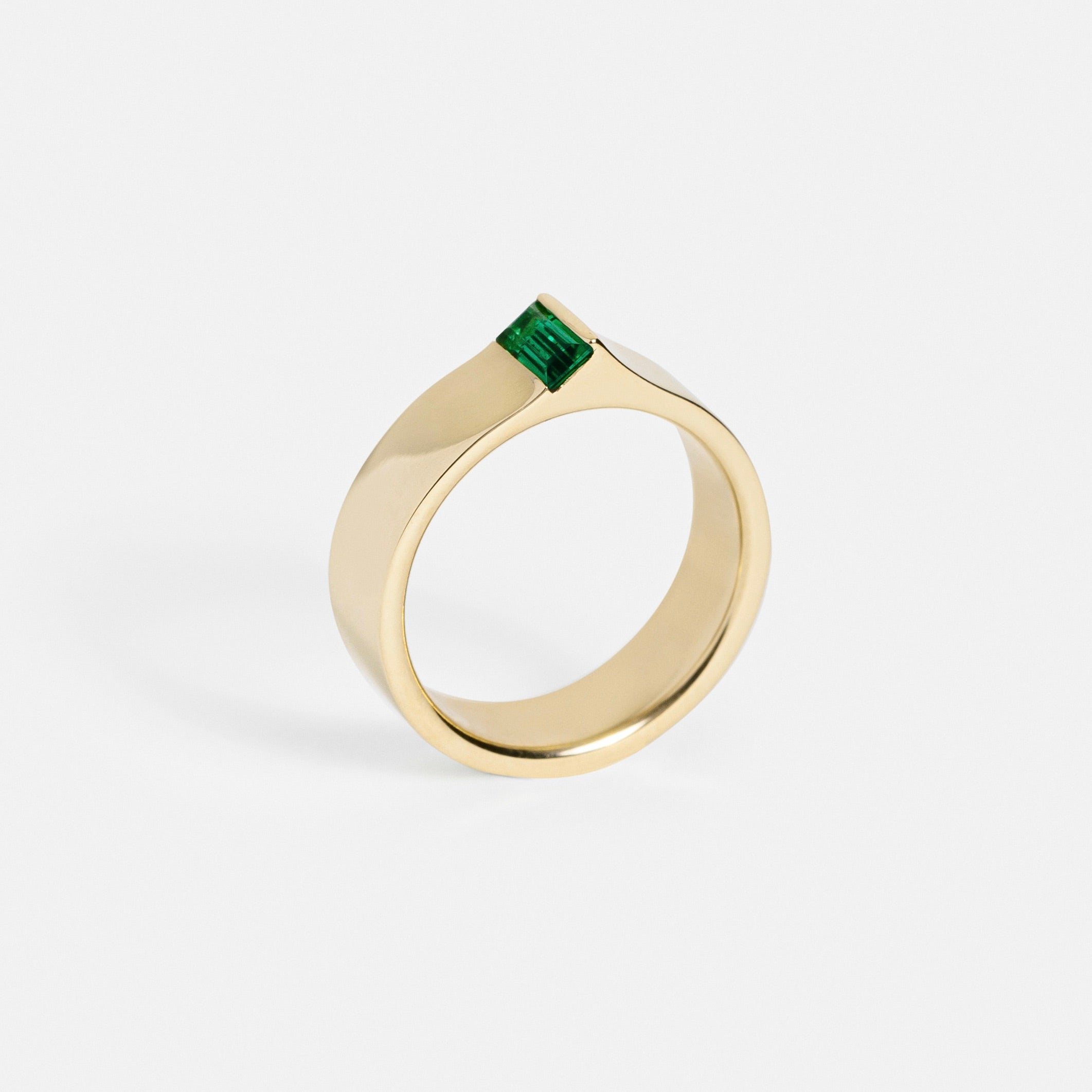 Thick flat gold ring with edge-set green baguette gemstone