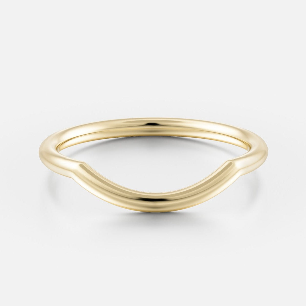 Close view of a delicate solid gold wedding band with curved silhouette