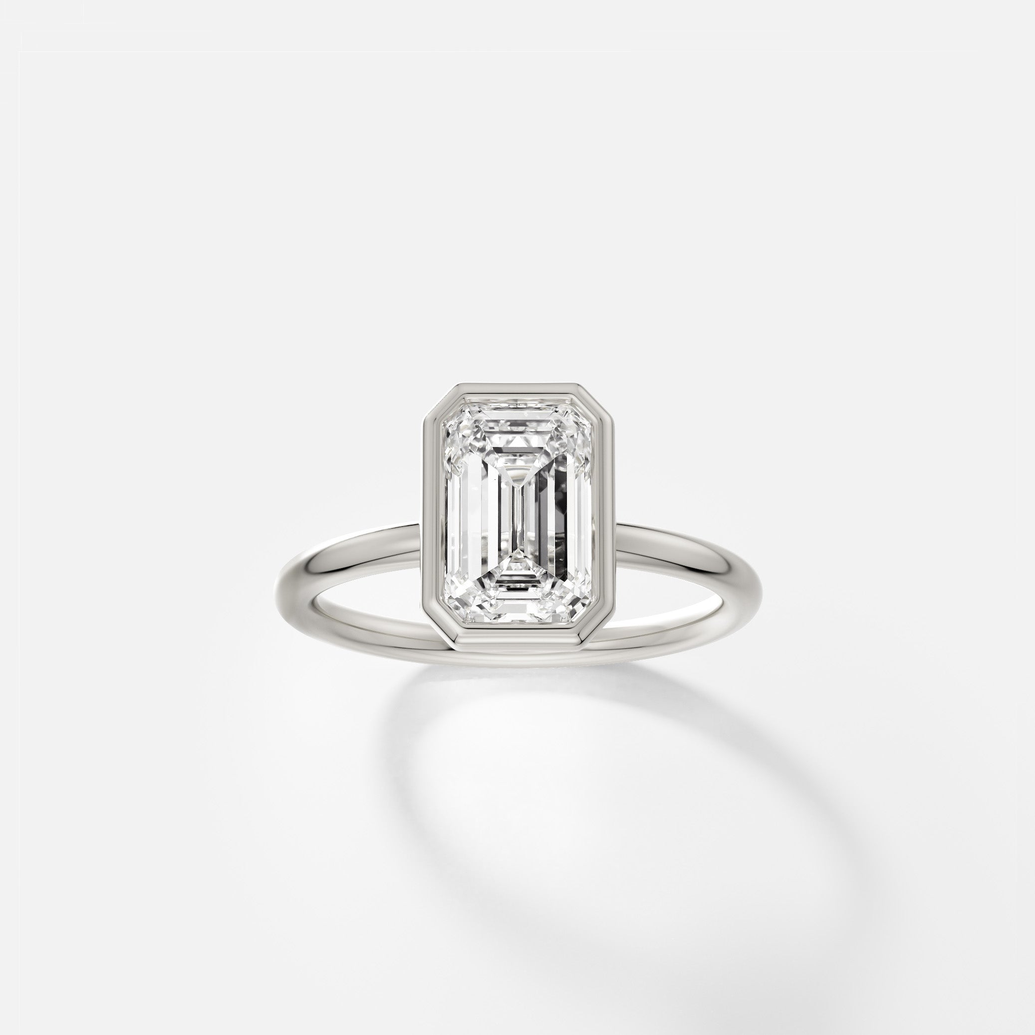 Platinum engagement ring with 2 carat round brilliant diamond in thin bezel on delicate round profile band