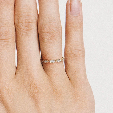 Minimal diamond band with marquise-cut stones shown worn in natural light