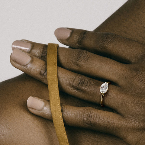 Close view of 1.00 carat oval diamond set east west with compass prongs