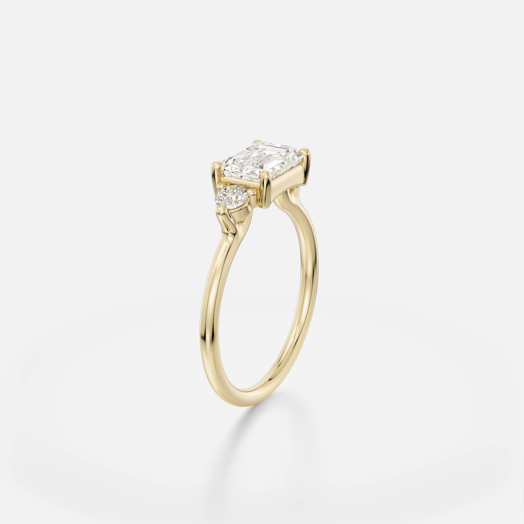 Dainty band engagement ring with east west emerald cut center and round side stones cluster design SHW Fine Jewelry NYC