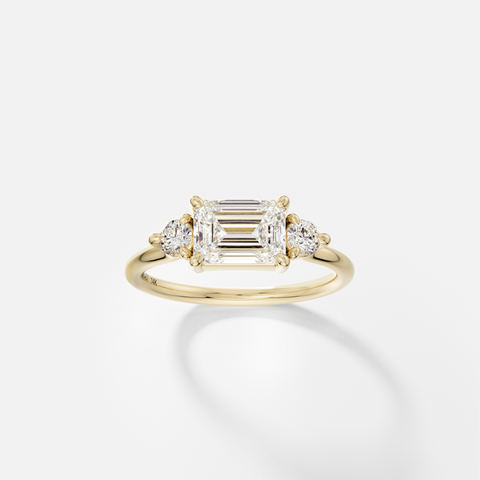 East West emerald cut engagement ring with round side diamonds three stone cluster 14k 18k gold platinum SHW Fine Jewelry NYC
