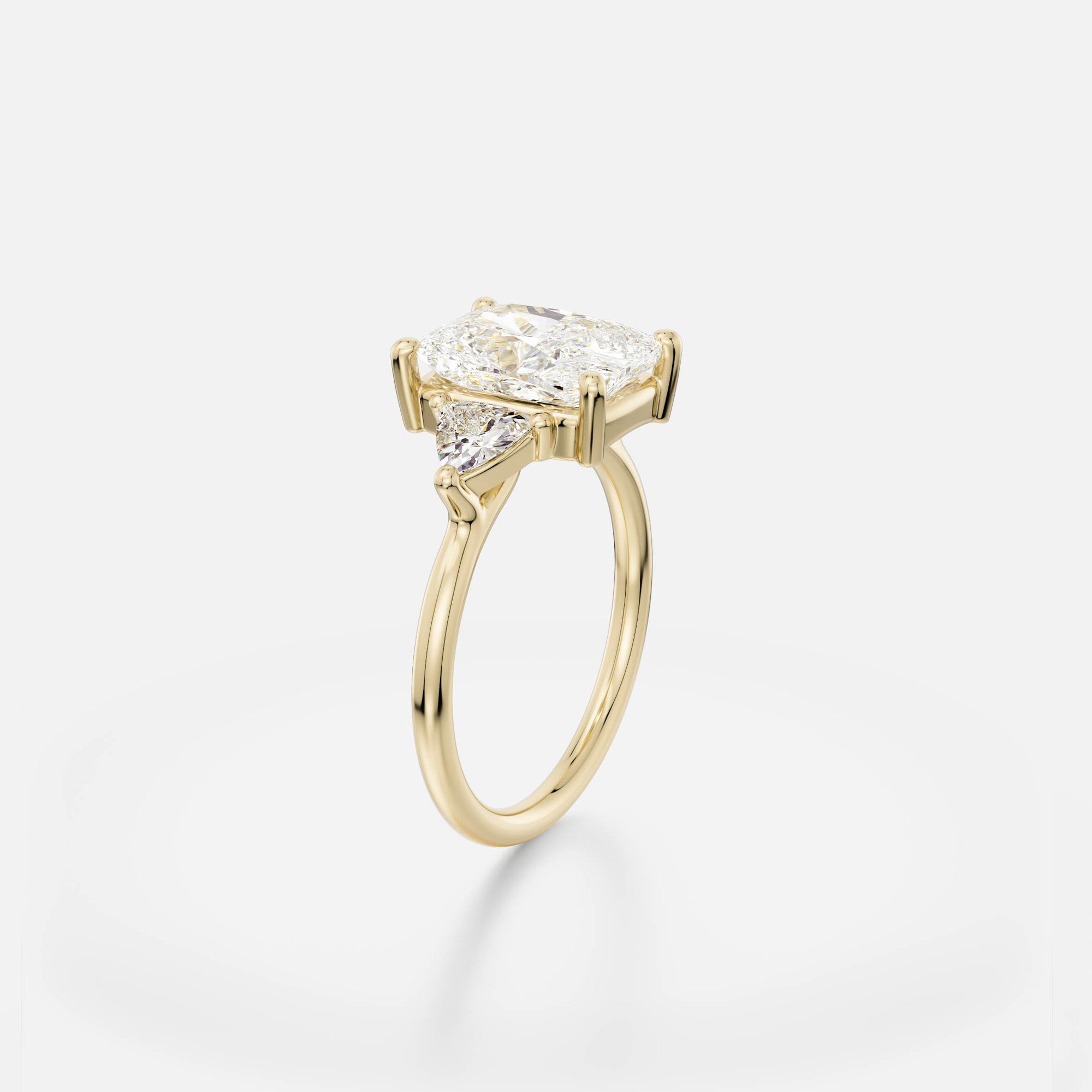3 carat elongated cushion diamond engagement ring with trillion side stones in delicate prong cluster setting