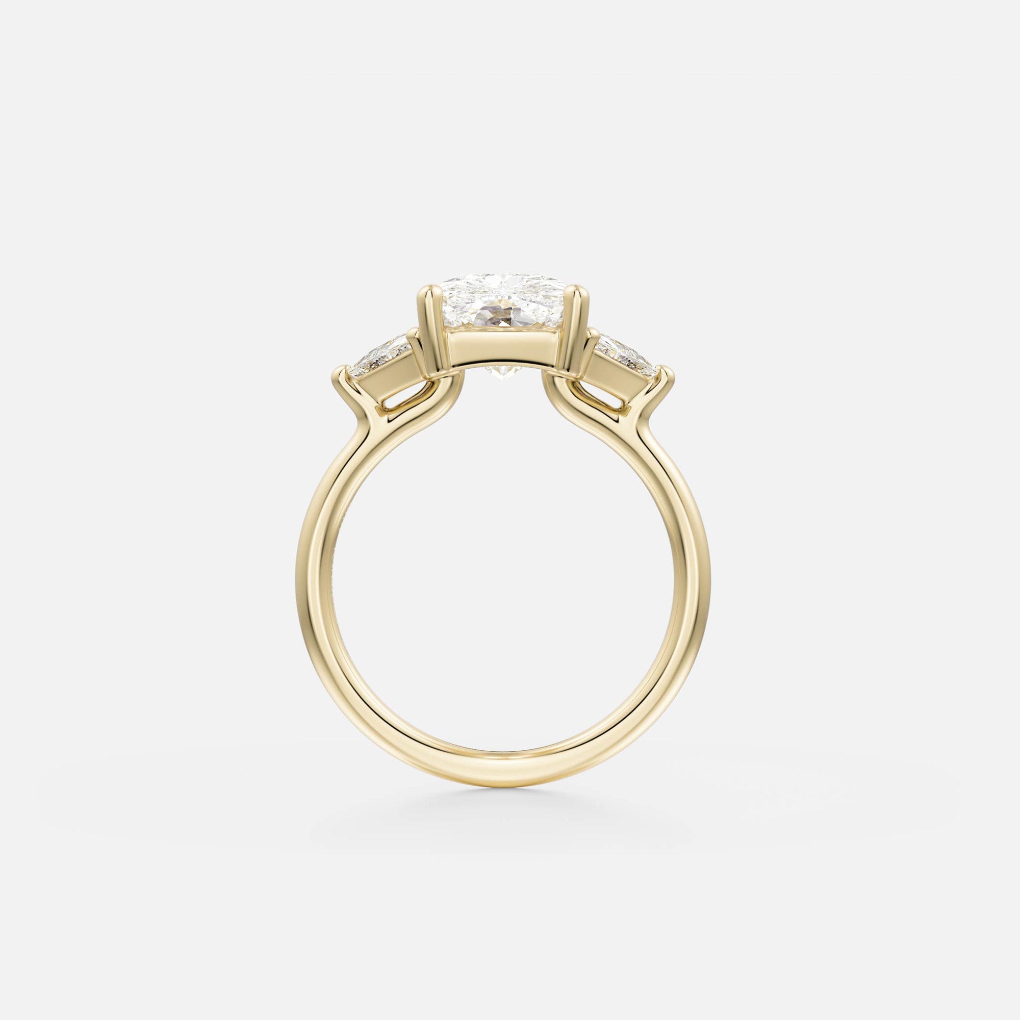 side view of elongated cushion diamond three stone engagement ring with trillion-cut side diamonds on thin round band
