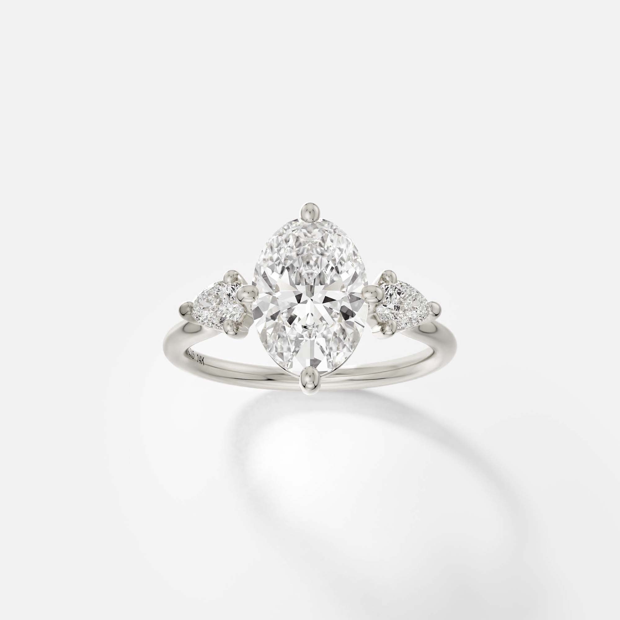 14k white gold engagement ring with 2.00 ct oval diamond and pear-cut side stones in compass prong cluster setting