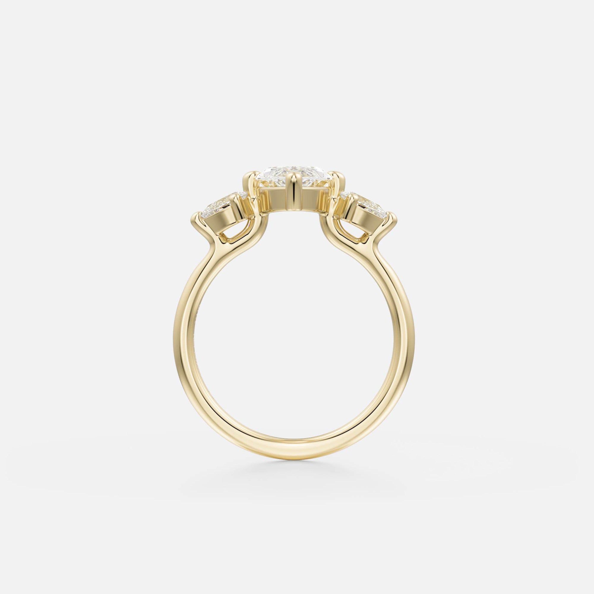 side view of marquise diamond three stone engagement ring with pear side stones on delicate round profile band open setting