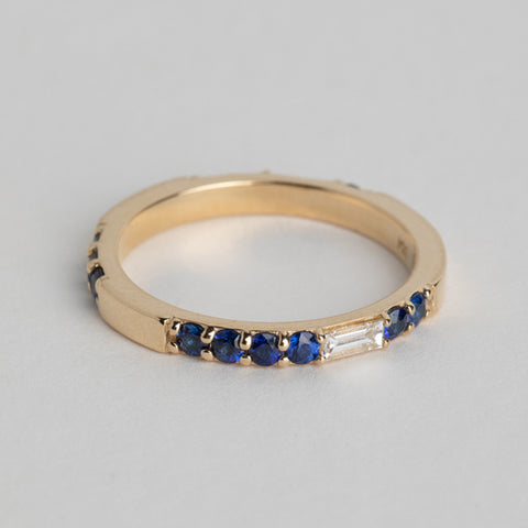 Close view of a 2mm eternity ring with round blue sapphires and white diamond baguettes