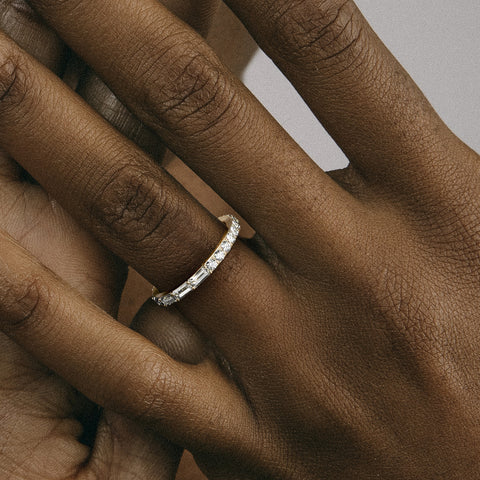 Asymmetrical diamond eternity band shown worn in natural light