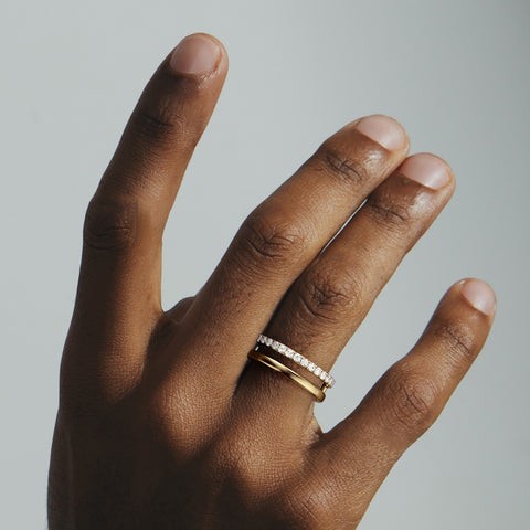 Asymmetrical pavé diamond wedding band shown worn in natural light