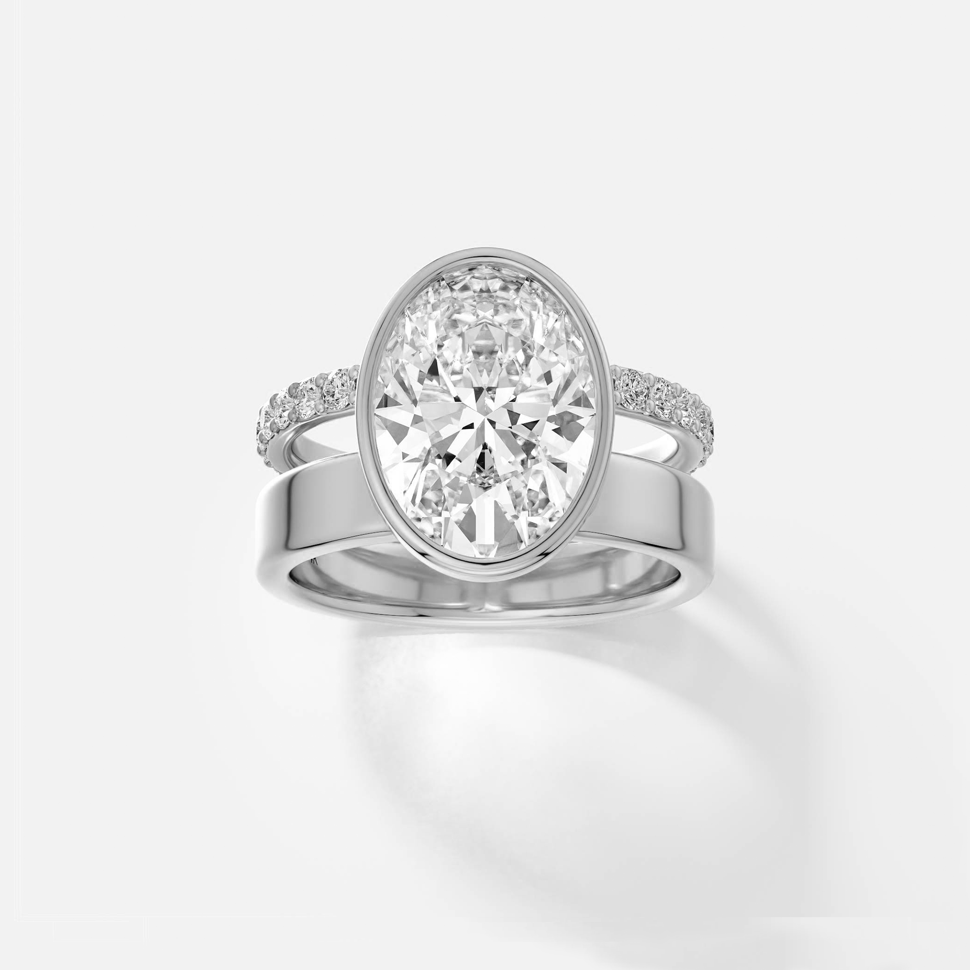 platinum engagement ring with 4.00 carat oval diamond bezel setting and pavé diamond eternity band on double band