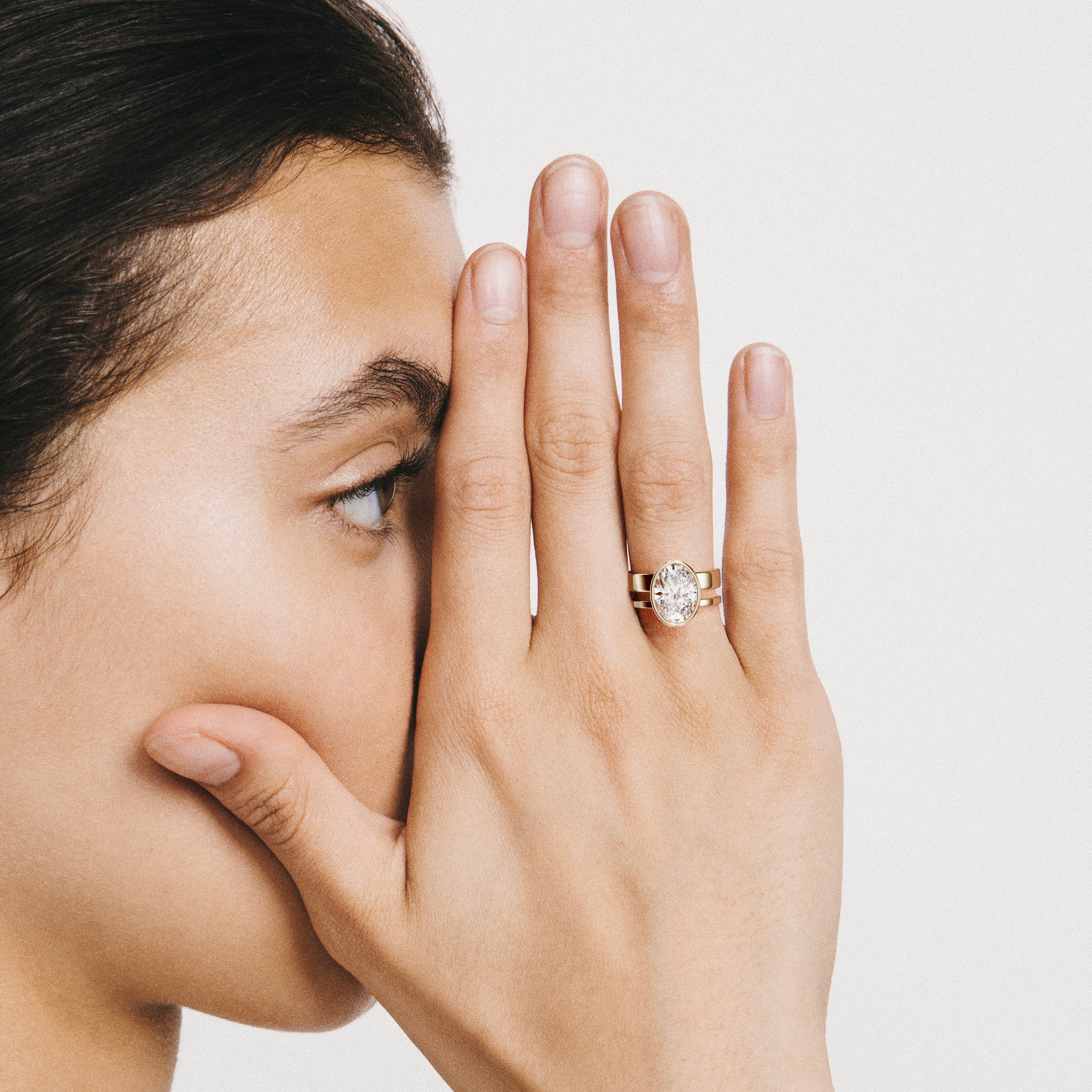 4.00 carat oval diamond bezel engagement ring on asymmetrical double band worn on hand