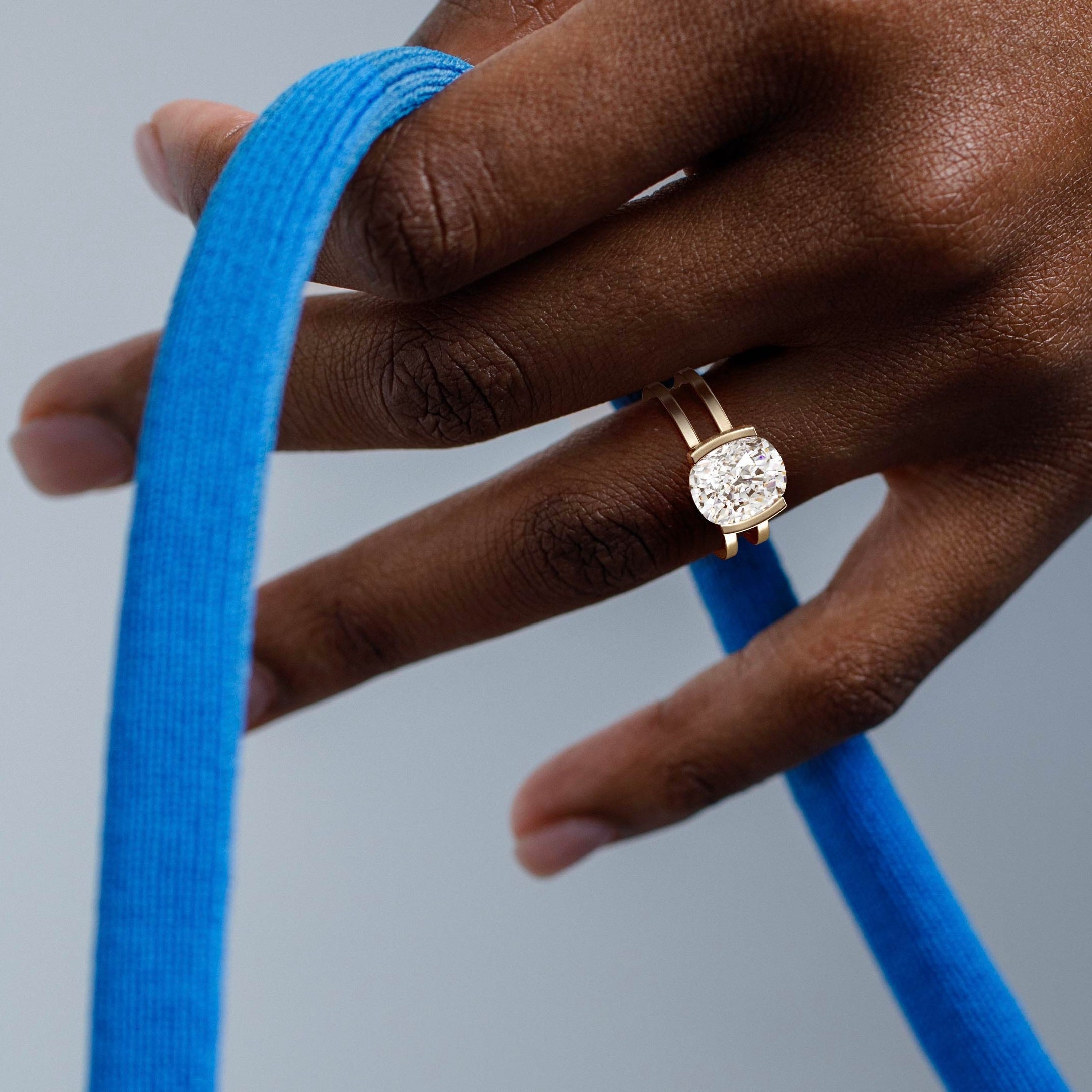 close view of elongated cushion diamond engagement ring with double band and partial bezel