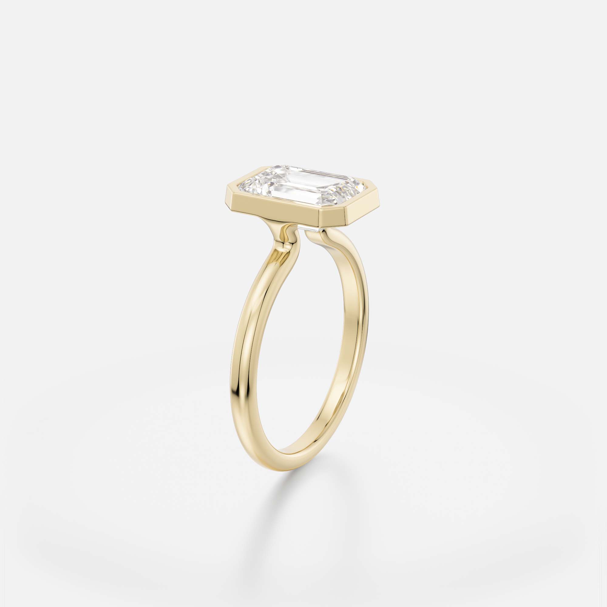 2.50 carat emerald-cut step-cut diamond engagement ring with slim bezel setting and open profile on domed band