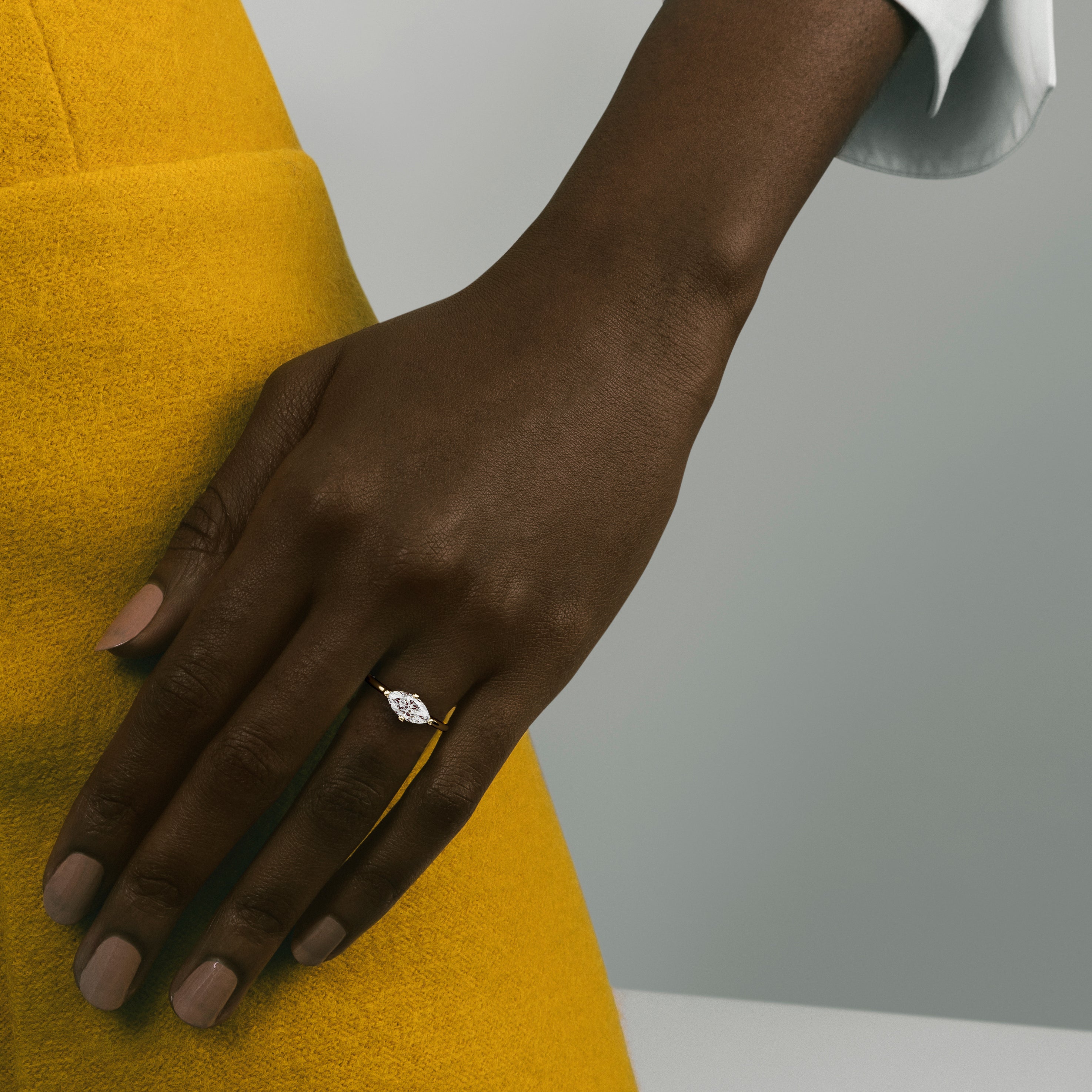 Dainty yellow gold engagement ring with 1ct marquise diamond worn on hand