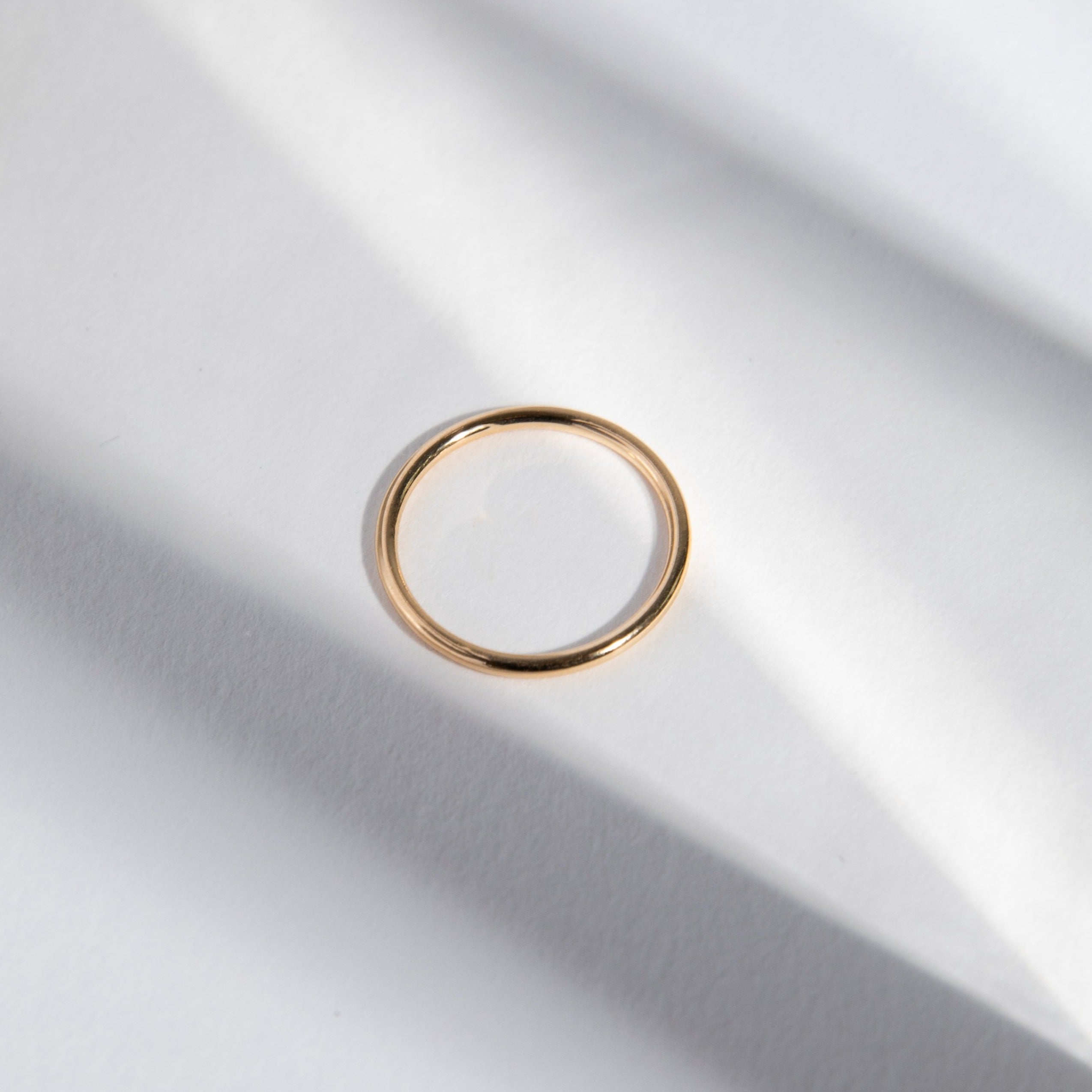 Side view of a slim round profile gold band
