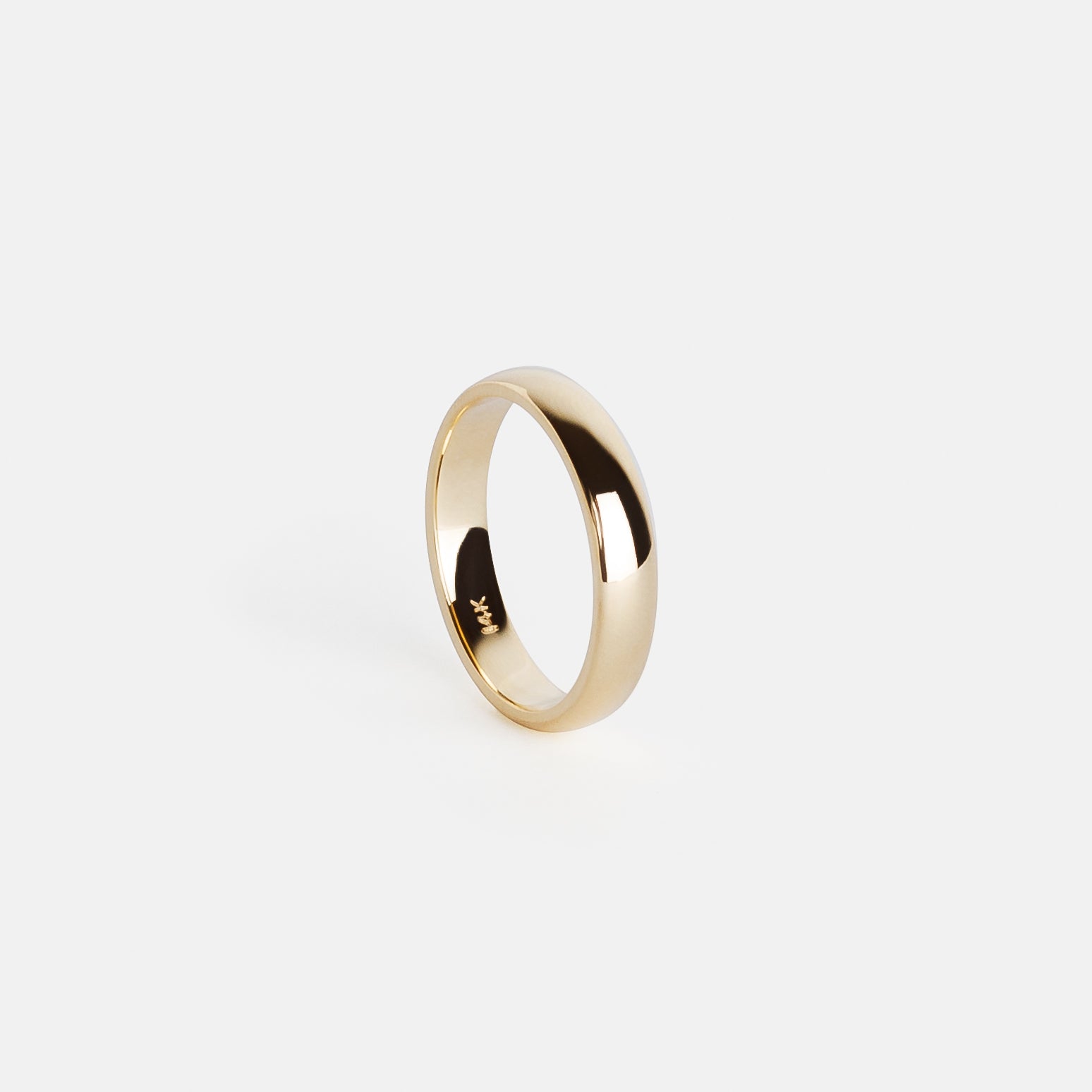 Side angle of a solid gold 4mm wedding band with domed silhouette