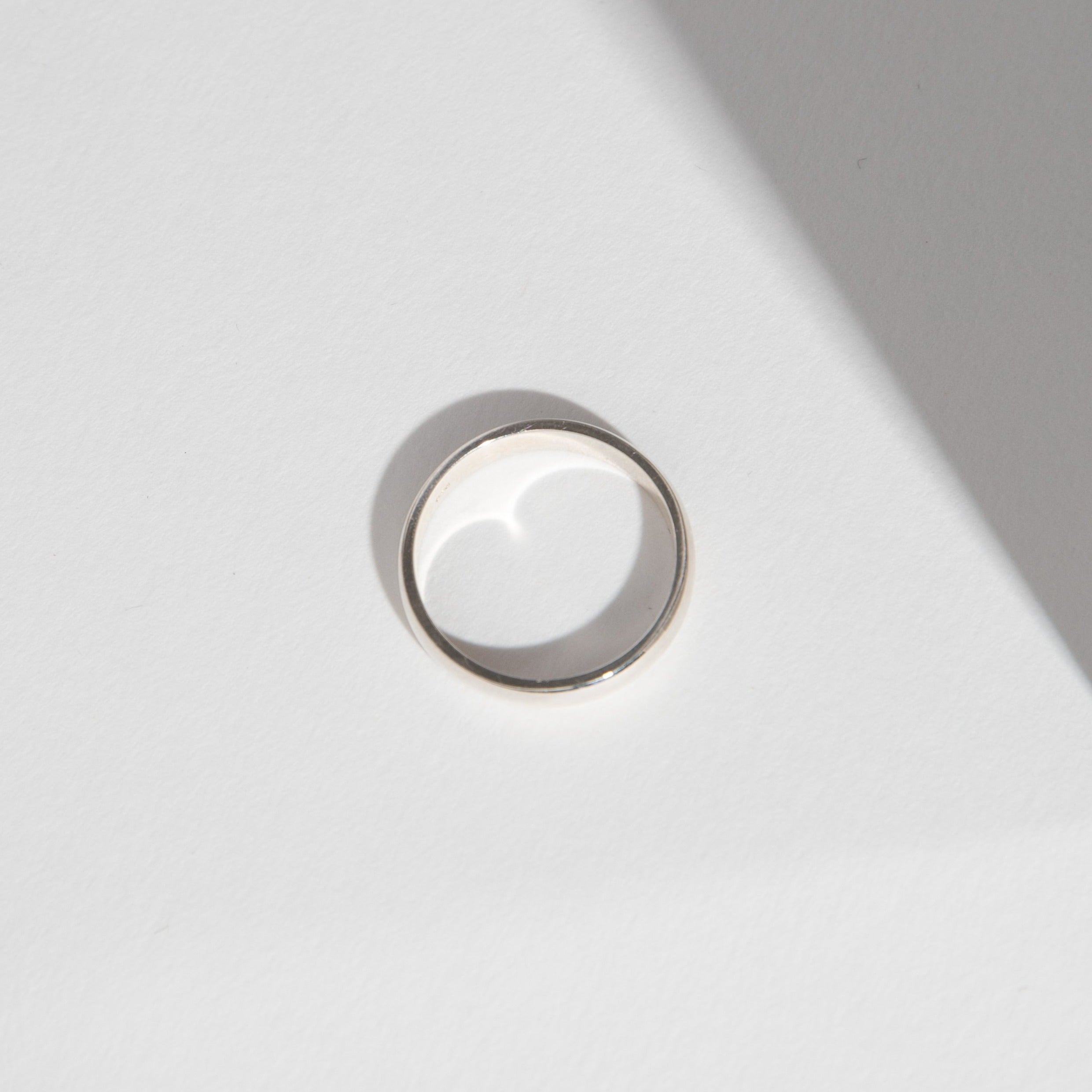 Side view of a 4mm white gold wedding band with domed design