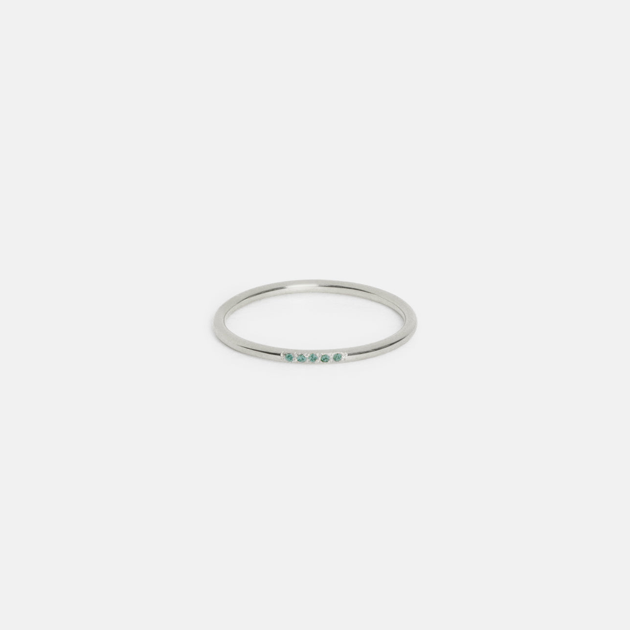 14k white gold slim round band with five emerald gemstones