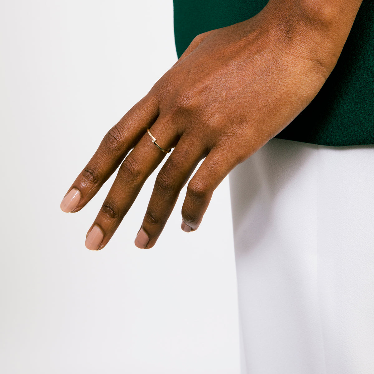 Dainty gold wedding band with four vertical diamonds worn on hand