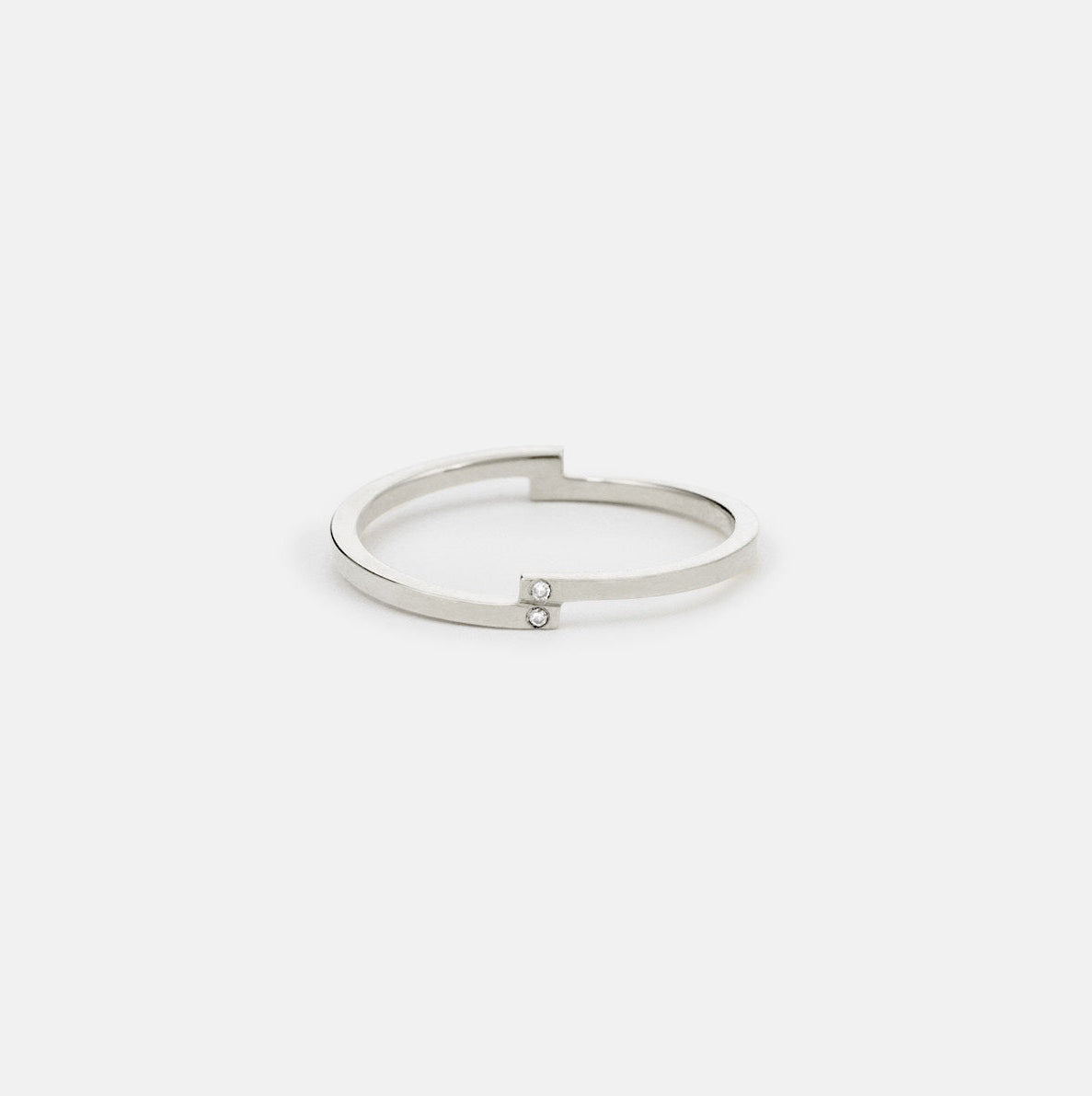 Thin off set white gold band featuring two vertically aligned diamonds